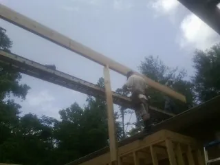 Carpenter setting a ridge beam over a new addition frame — Ice Dam Removal by Roofing Brothers in Braddock Heights