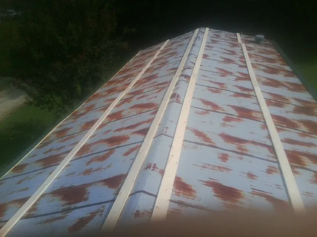 Rusted metal roof panels with new wood purlins before replacement — Storm Damage Roof Repair in Braddock Heights by Roofing Brothers