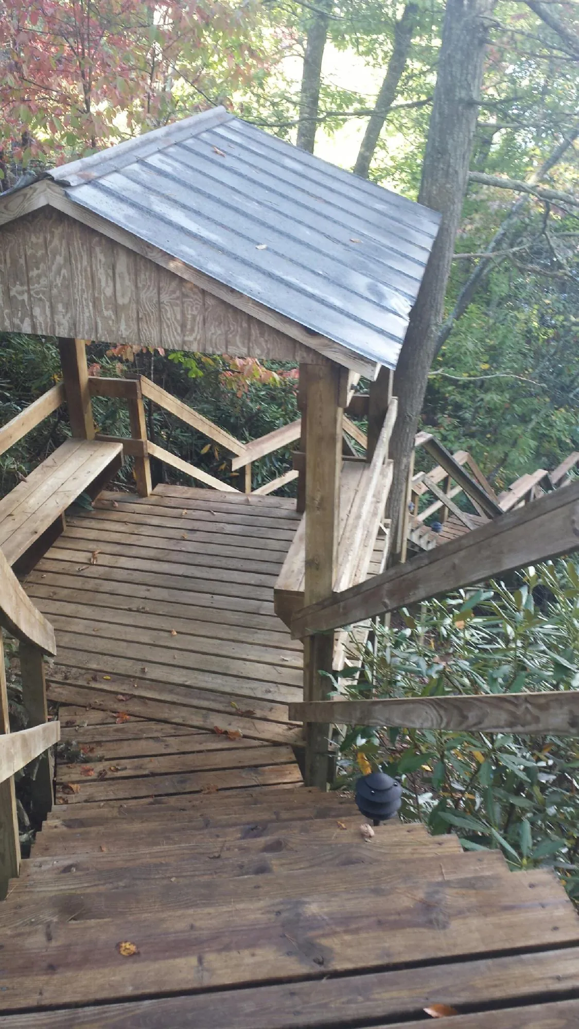 Metal roofed shelter over wooden steps on a wooded walkway — Skylight Repair & Installation work by our crew in Braddock Heights