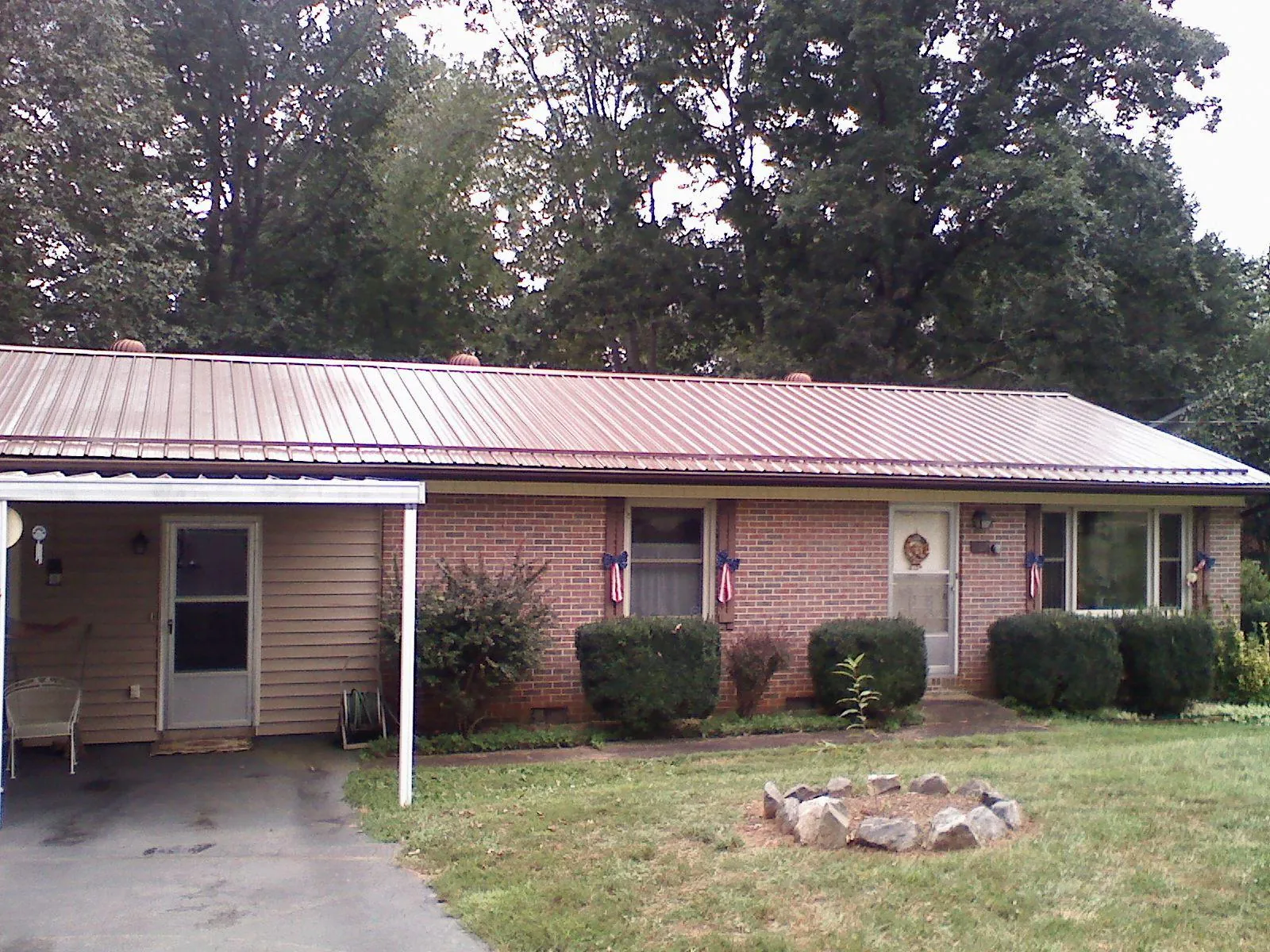 Bronze metal roof and carport on a brick ranch home — Roof Repair work by our crew in Braddock Heights